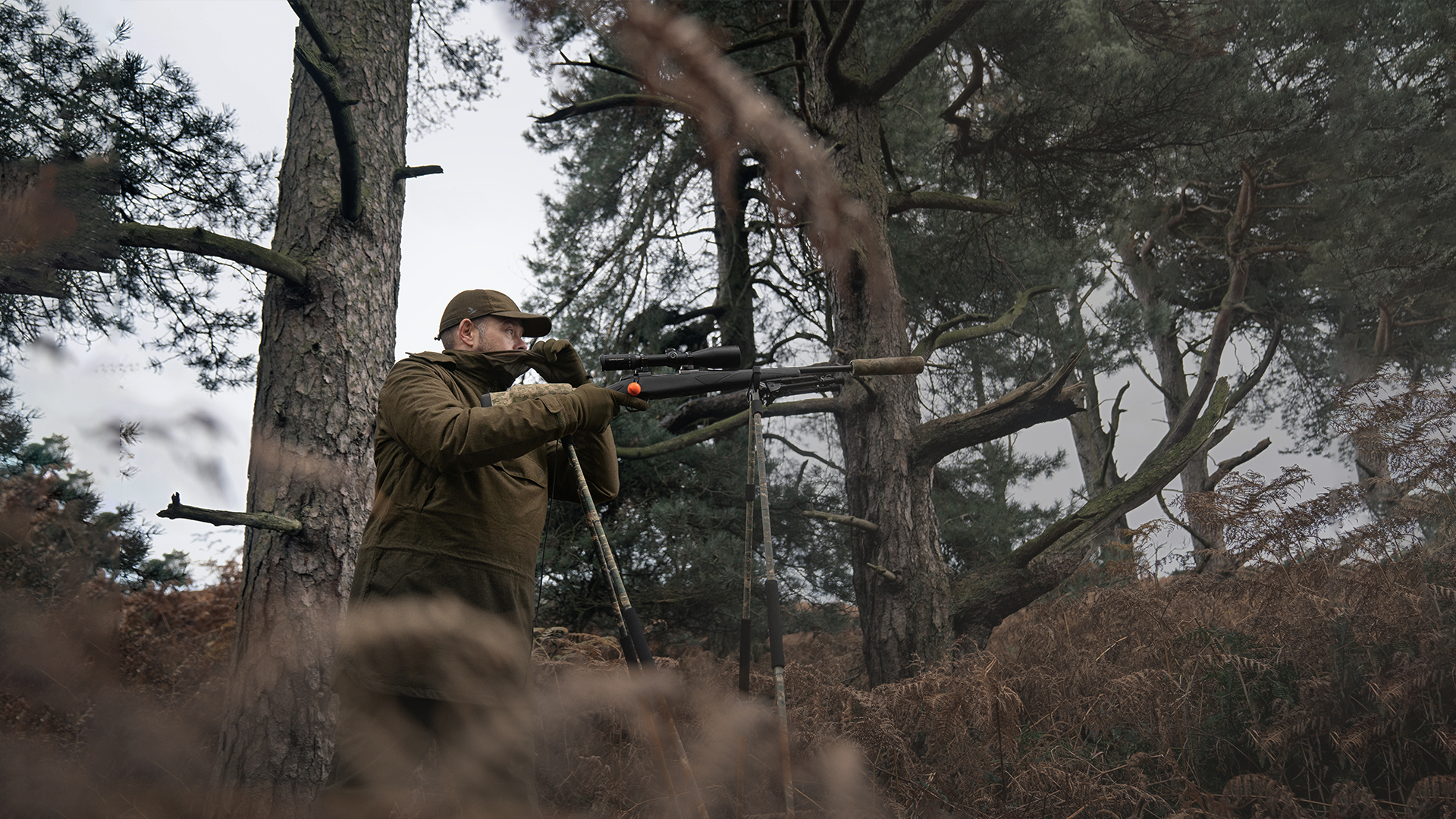 Jæger gemt i skoven med sin skydestok